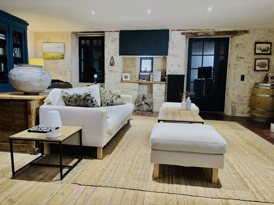 Salon avec canapé blanc, pouf et tapis