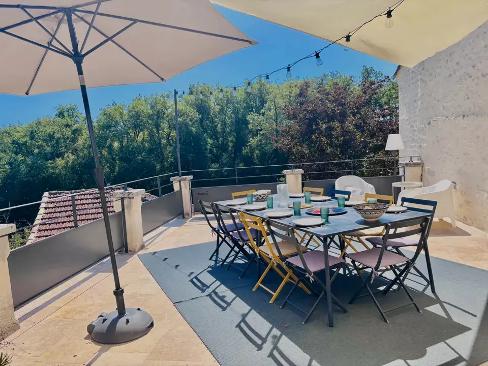 Terrasse du haut avec grande table et parasol